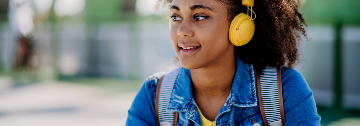 Multiracial,Teenage,Girl,With,Backpack,,Headphones,And,Smartphone,Resting,After